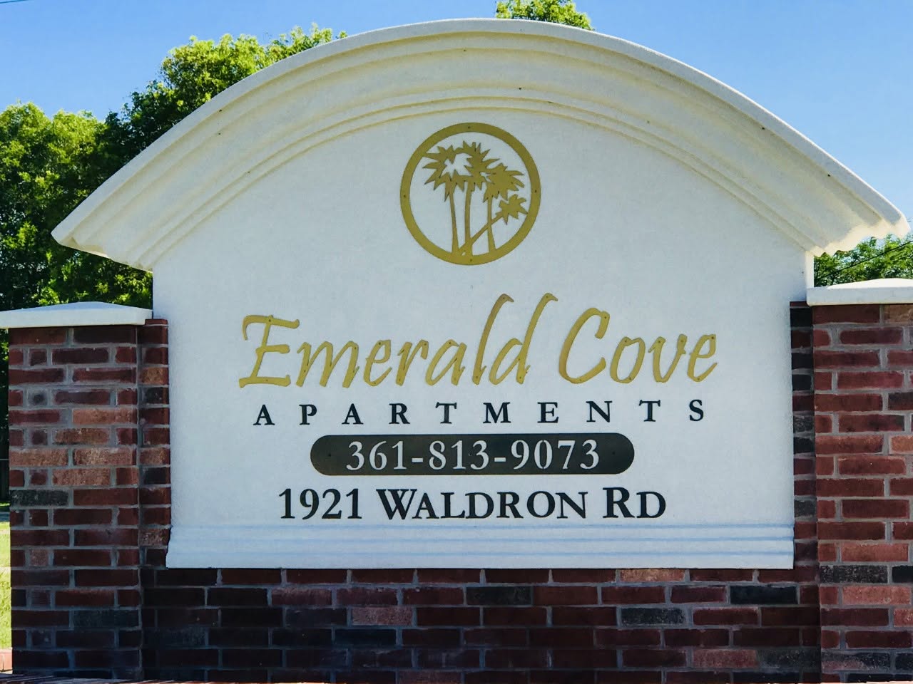 Emerald Cove Apartments entrance sign reading 1921 Waldron Rd and phone number 361-813-9073